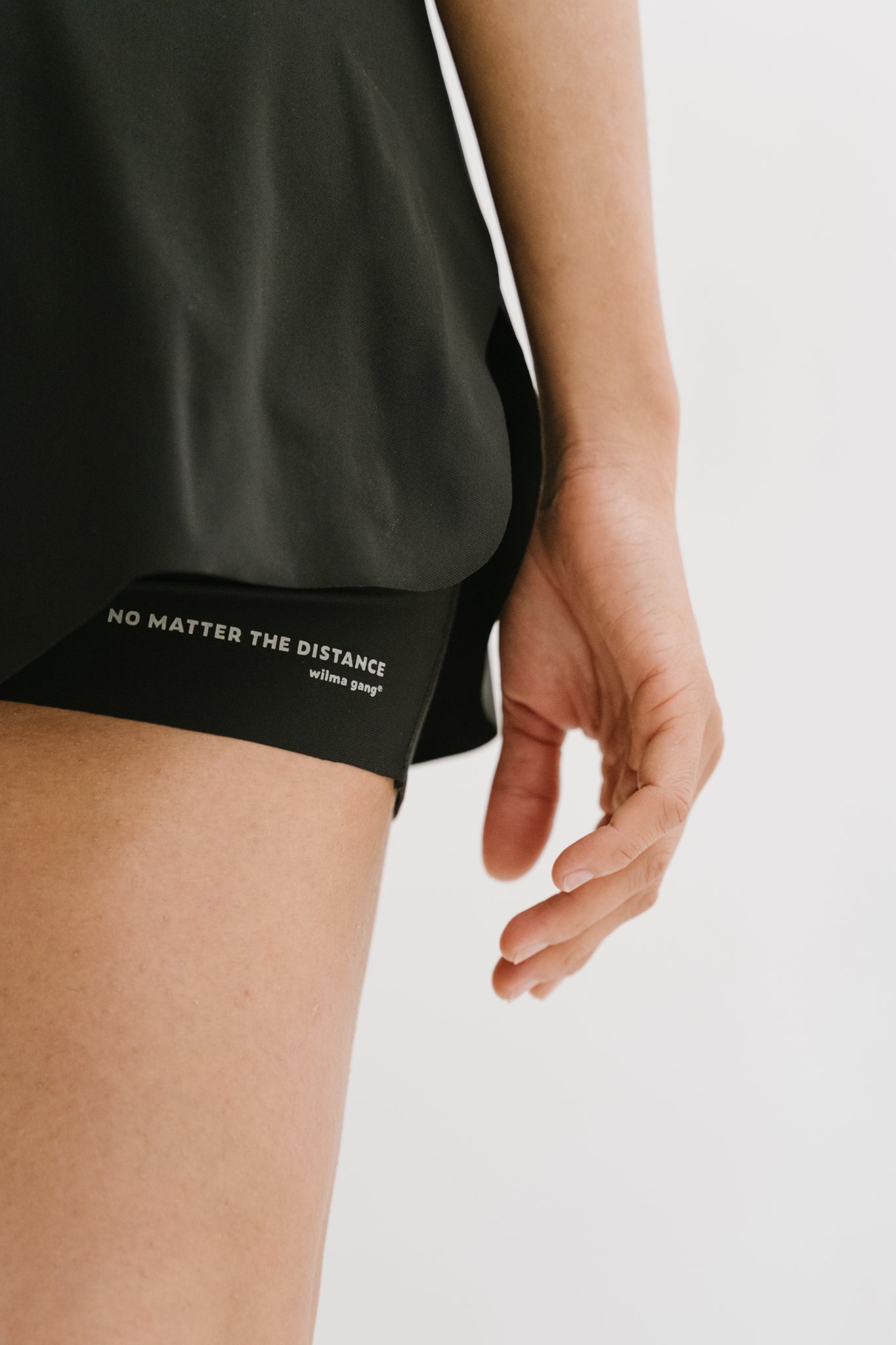 Détail du flocage 'No Matter The Distance' sur le côté gauche du short Rachel, soulignant l'inspiration et la motivation pour les coureuses. #color_Noir
