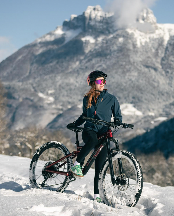 Photo d'une femme à vélo avec un coupe vent et un cuissard de cyclisme menstruel Wilma