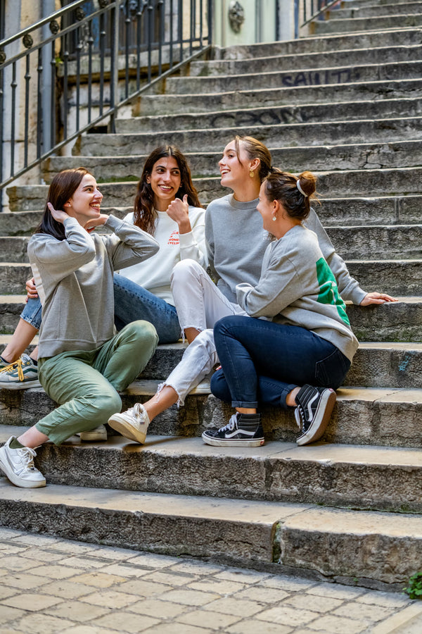quatre femmes portant un sweatshirt we believe in women cycling et assises devant la boutique Wilma