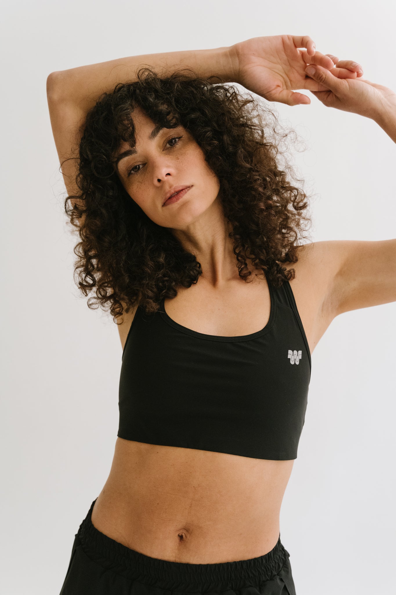 Sportive portant la brassière de sport Robyn pendant un jogging, démontrant le confort et le maintien. #color_Noir