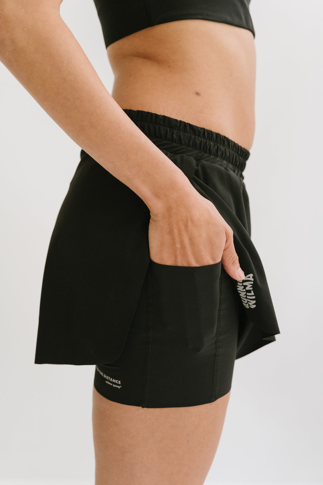 Gros plan sur la poche cargo latérale du short Rachel, pratique pour transporter des essentiels comme des gels énergétiques ou des clés. #color_Noir