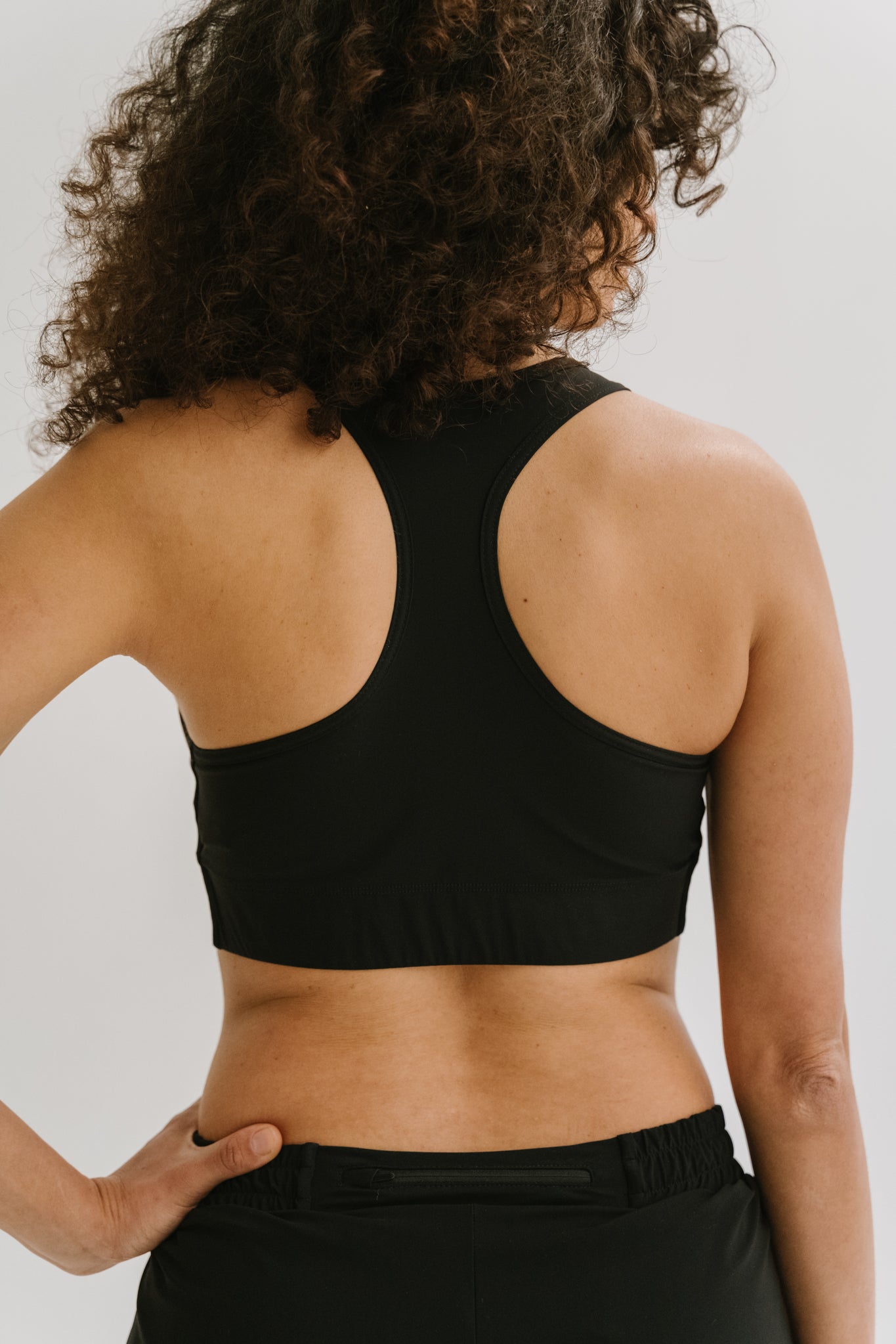 Vue arrière de la brassière de running Robyn, mettant en évidence le design du dos et les finitions.#color_Noir