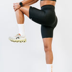 Short de running pour femme anti-frottement Nina noir vu de profil avec une jambe pliée