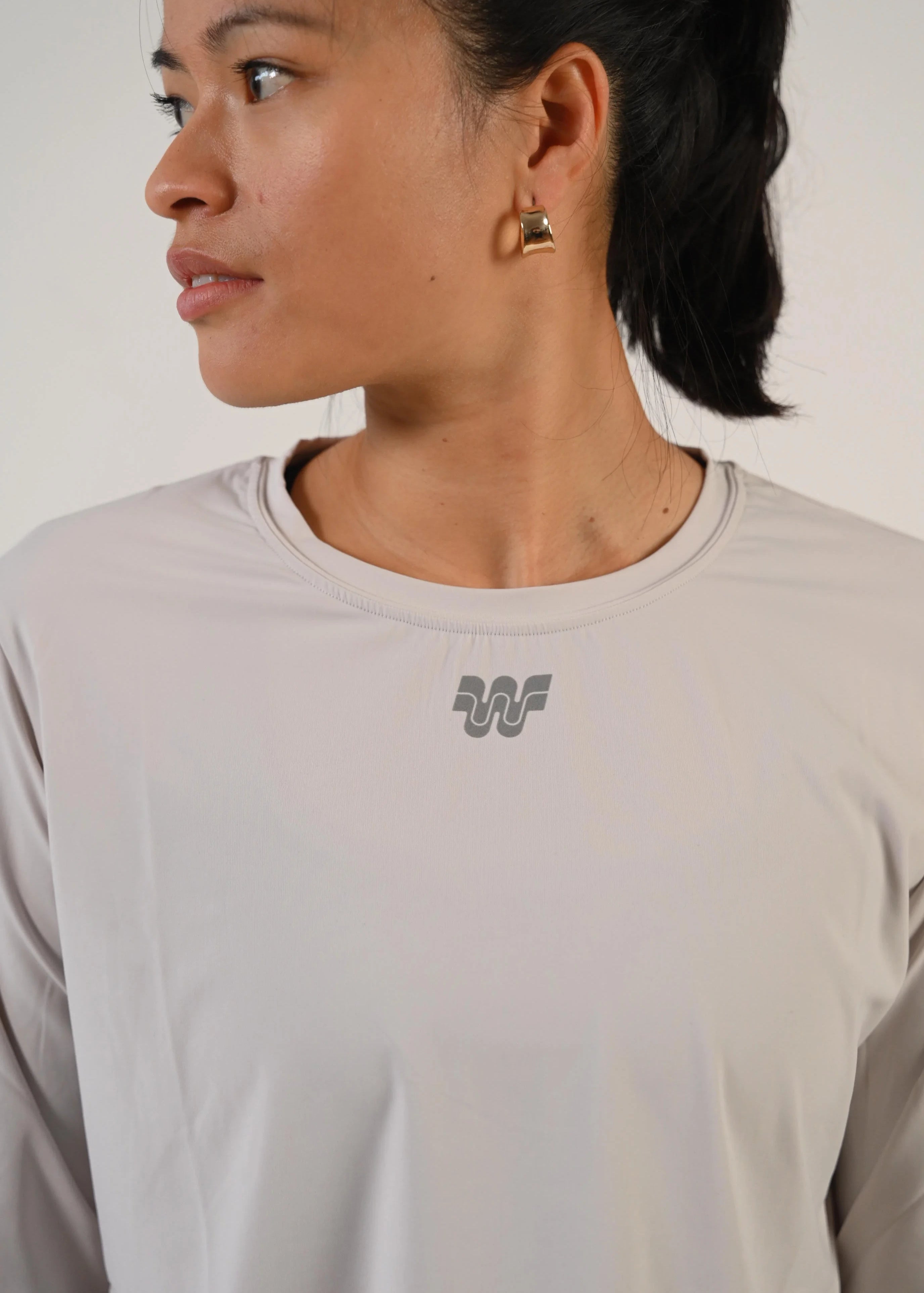 Portrait de profil d'une femme en t-shirt de running manches longues Mia gris clair - Wilma
