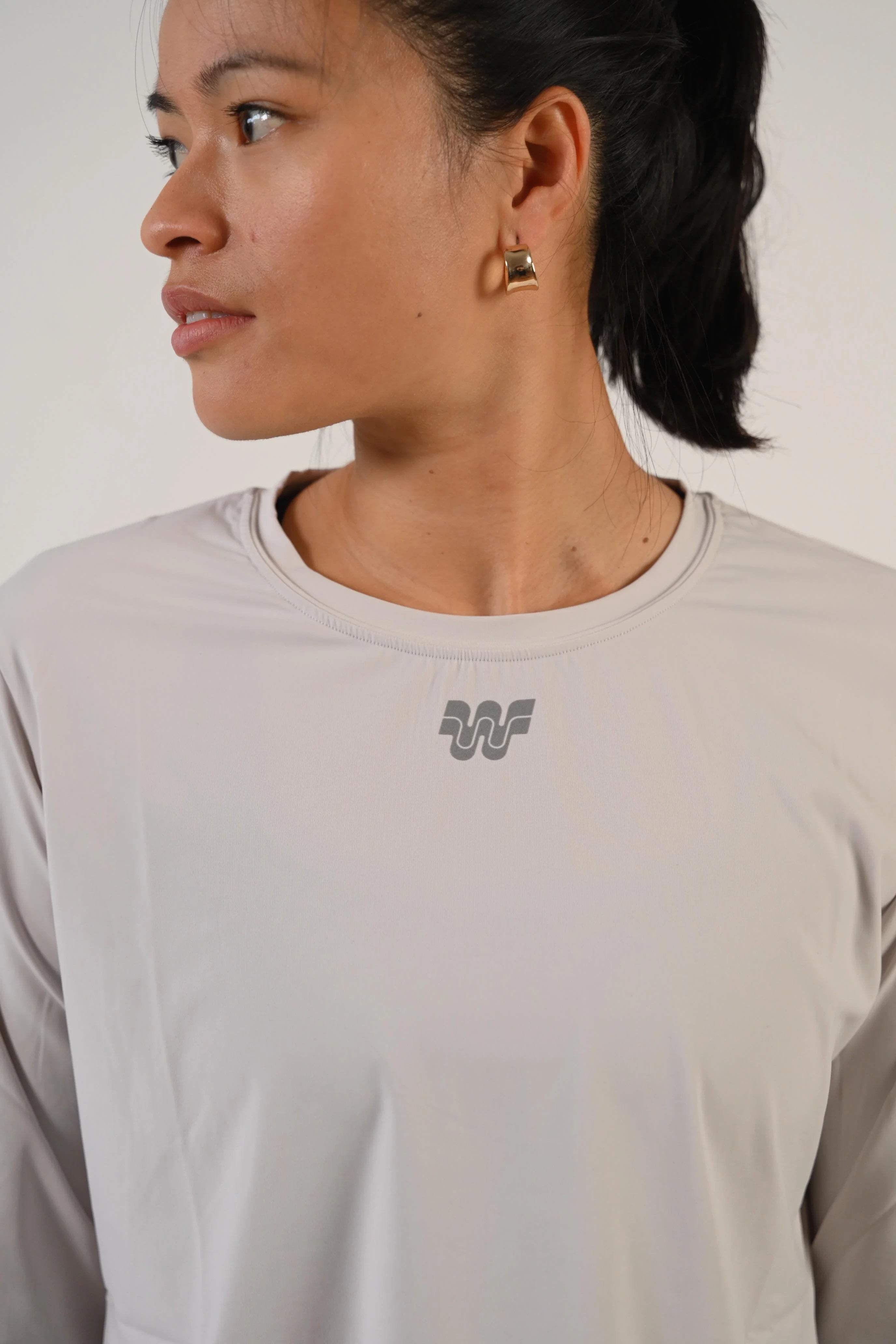 Portrait de profil d'une femme en t-shirt de running manches longues Mia gris clair - Wilma