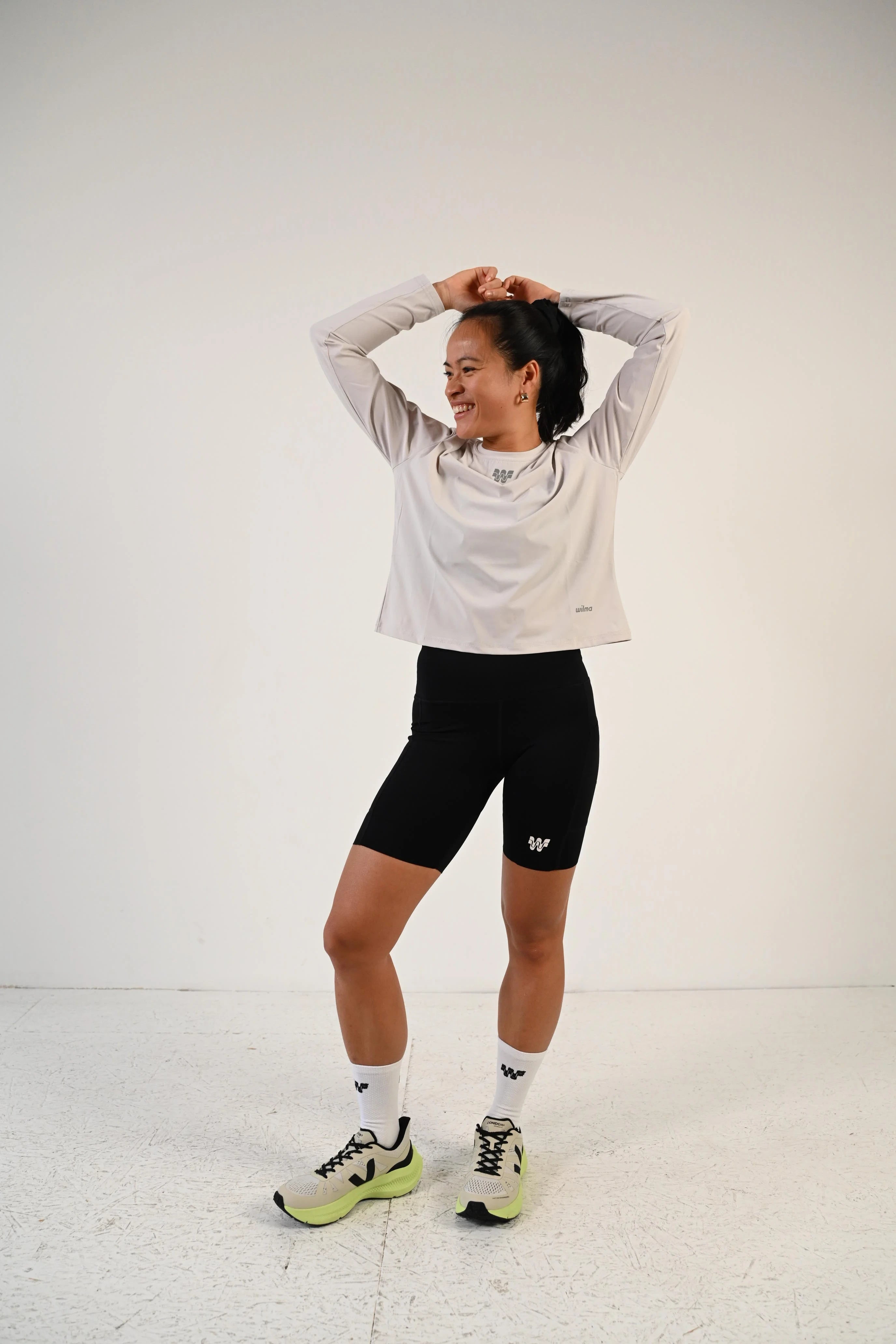 Coureuse en mouvement portant le t-shirt de running manches longues Mia gris clair - Wilma
