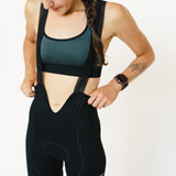 Femme qui porte le cuissard de cyclisme menstruel Wilma noir, vue de devant