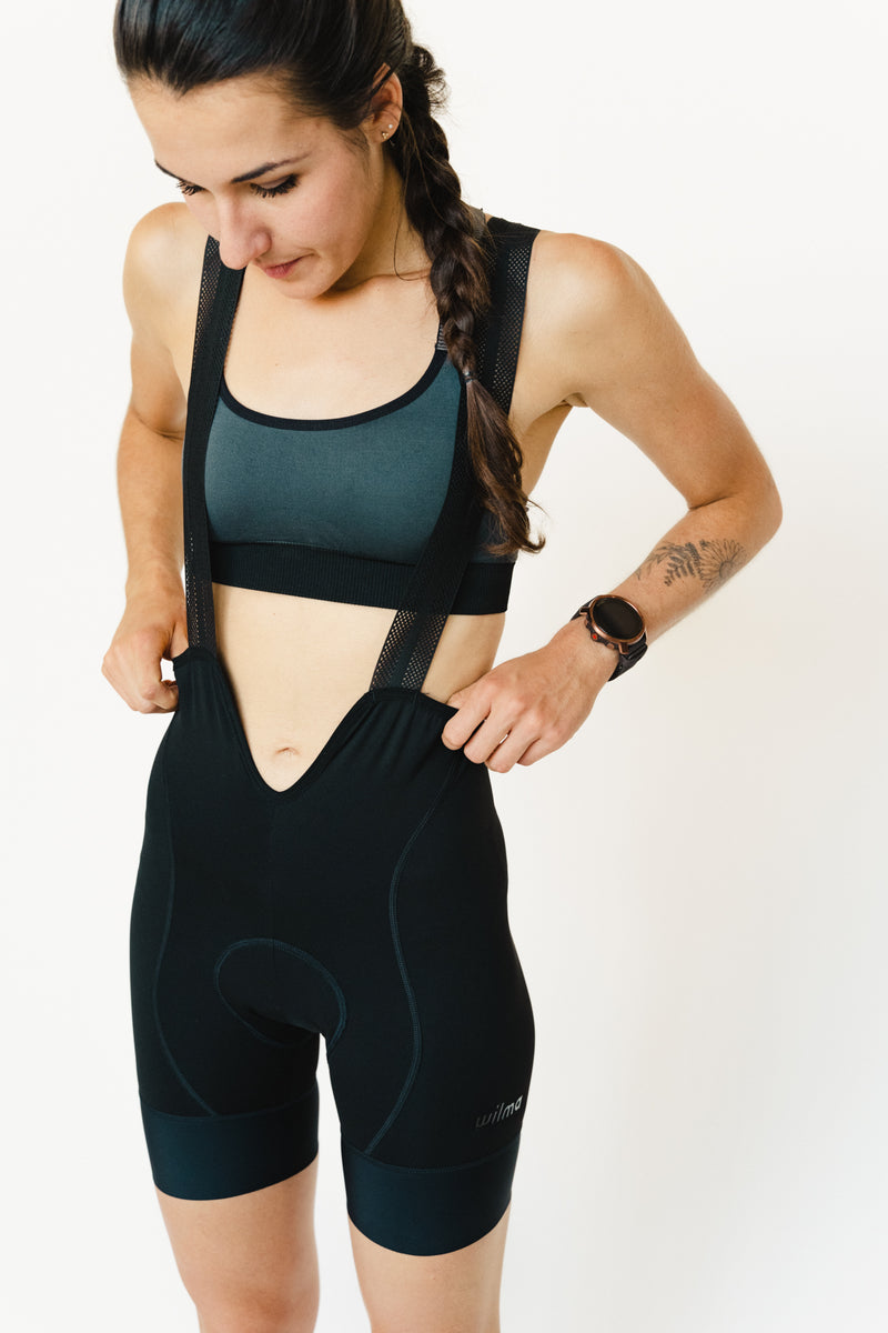 Femme qui porte le cuissard de cyclisme menstruel Wilma noir, vue de devant