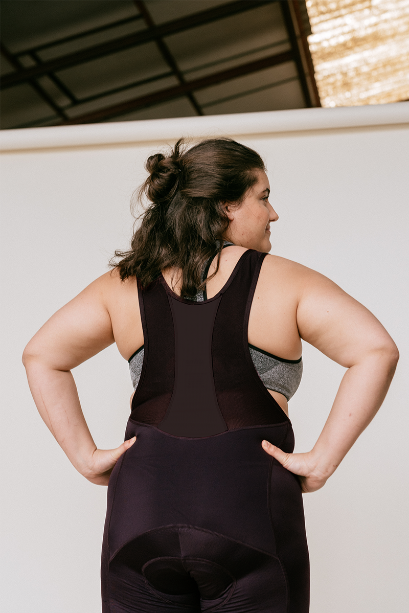 Femme qui porte le bibshort menstruel à bretelles de la marque de vêtements de cyclismeWilma, couleur aubergine, taille XL